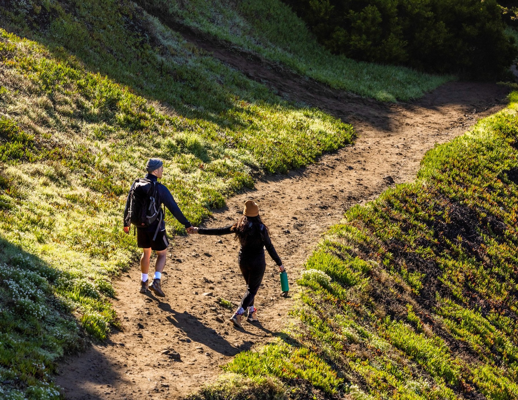 Two people hiking together on a sunny trail